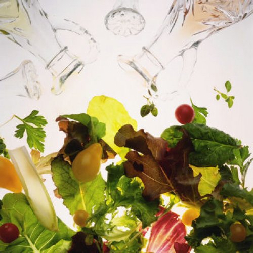 putting oil and vinegar on salad